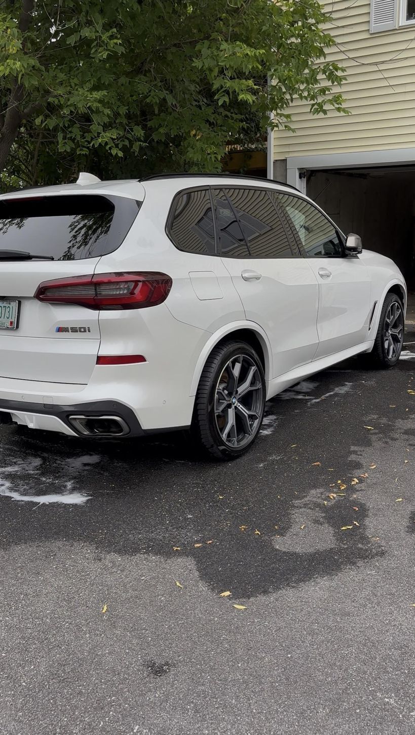 White BMW X5 in a driveway after a ceramic coating