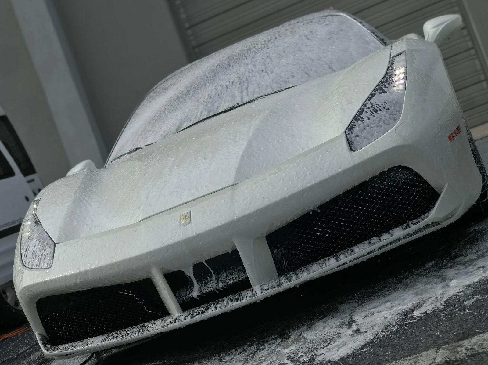 White Ferrari covered in foam during a hand wash