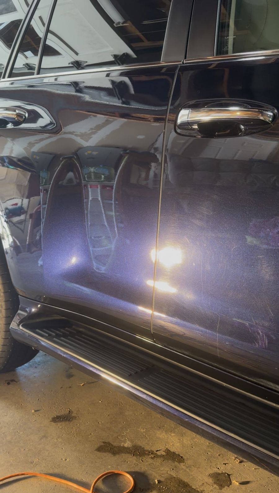 Inspection light reflecting in freshly corrected dark paint, swirl-free